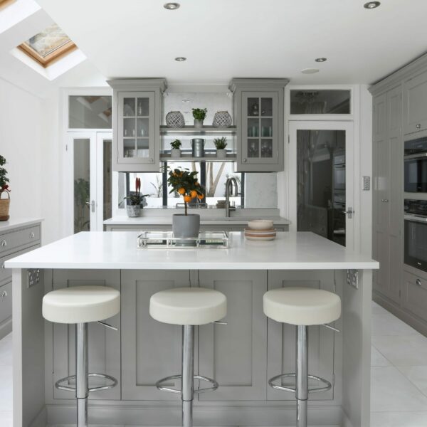Clapham Painted Shaker Kitchen with a central island, dressers, glazed wall cabinets, integrated fridge freezer, and an induction hob built into a chimney