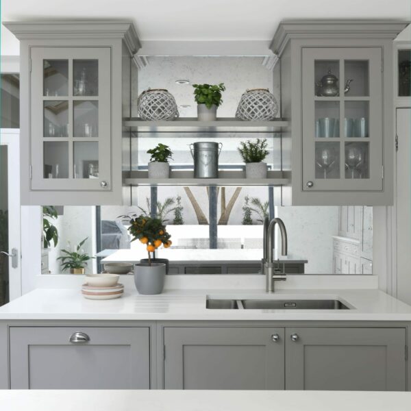 Clapham Painted Shaker Kitchen stainless steel sink with glazed wall cabinets above and floating shelves, a mirror splashback reflecting garden views