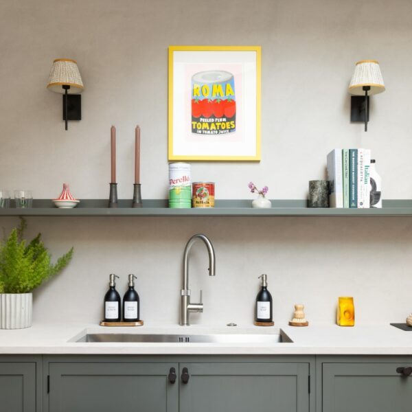 Shaker kitchen with large stainless steel sink and a stainless steel Quooker boiling water tap, a floating shelf above with candles, ornaments and cook books. Sconces on the wall add interest.