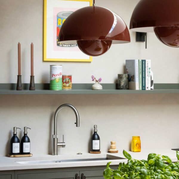 Shaker kitchen with vermillion red round pendant lights above island.