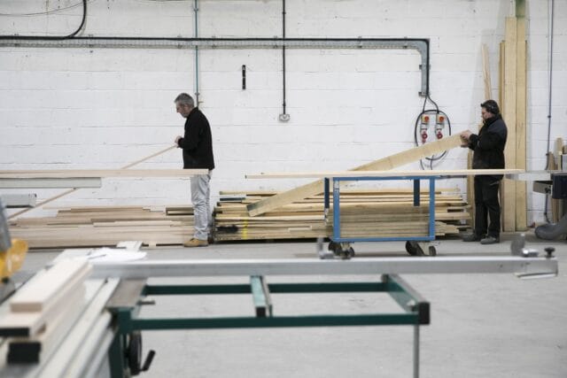 Busy cabinetmaking workshop at Higham Furniture with craftsmen assembling handmade kitchens