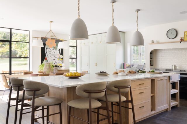 Luxury open-plan bespoke kitchen with large island and bar seating in a modern family home
