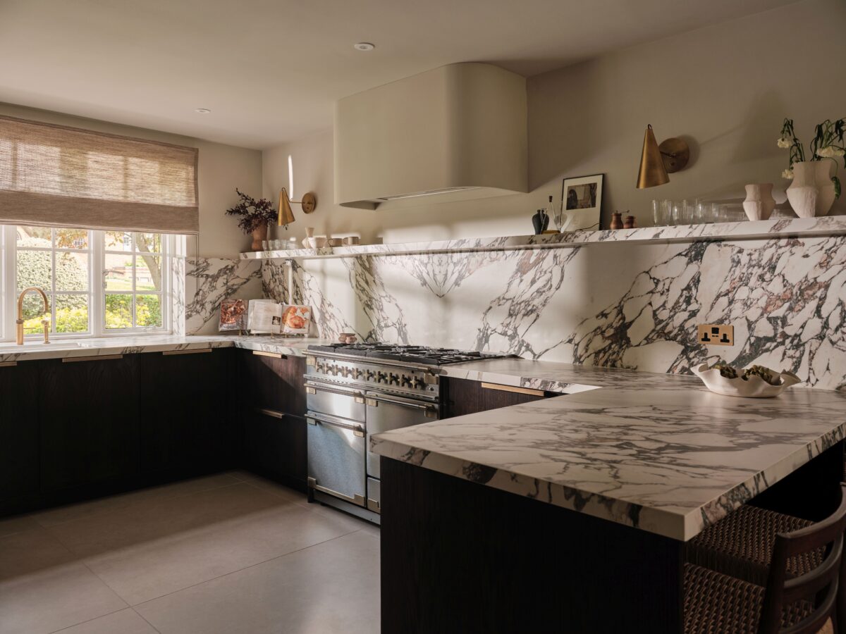 Bespoke contemporary kitchen with dramatic marble worktops, dark cabinetry and a stainless-steel range cooker