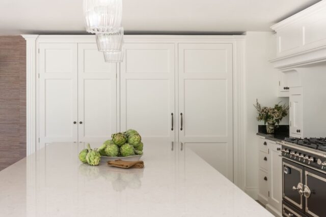 Handmade white shaker kitchen with range cooker and island in a bespoke luxury London home