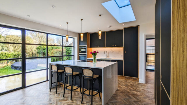 Bespoke modern kitchen by Higham Furniture with island, skylight and large glass doors in London extension