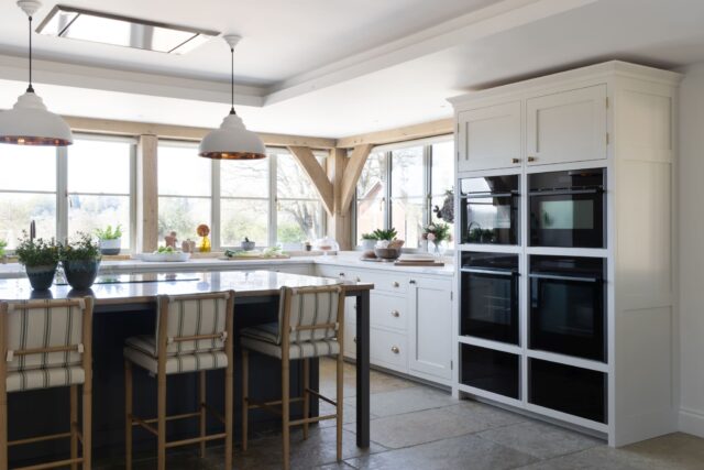Bespoke painted kitchen with island seating, timber beams and natural light by Higham Furniture