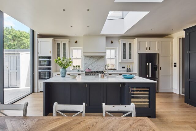 In-frame kitchen with dark island, cream cabinets and large sliding doors