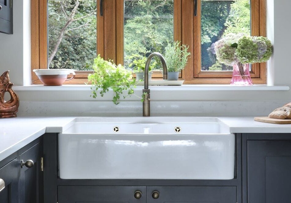 Villeroy & Boch Farmhouse Sink Villeroy & Boch Farmhouse Sink, patinated brass Quooker tap in front of window with garden views.